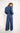 Woman wearing a blue striped jumpsuit on a white background