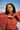 Woman wearing a red lace top with a mountainous background