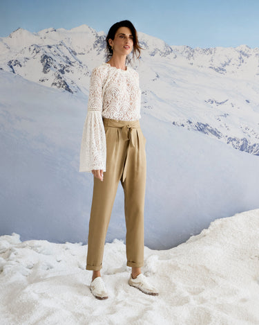 Person standing on a snowy mountain with a snowy mountain range in the background