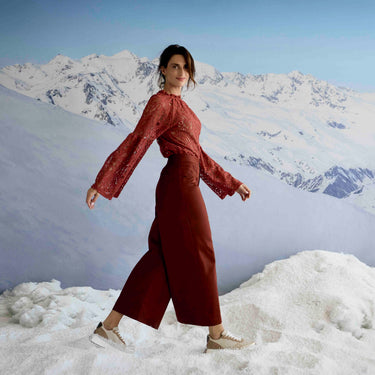 Person in a red outfit standing on a snowy mountain