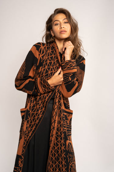 Woman wearing a patterned brown and black coat on a white background