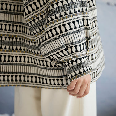 Person wearing a patterned jacket with a blurred background