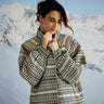 Woman wearing a patterned coat with snow-covered mountains in the background