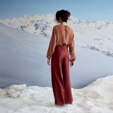 Person standing in a snowy landscape with mountains in the background